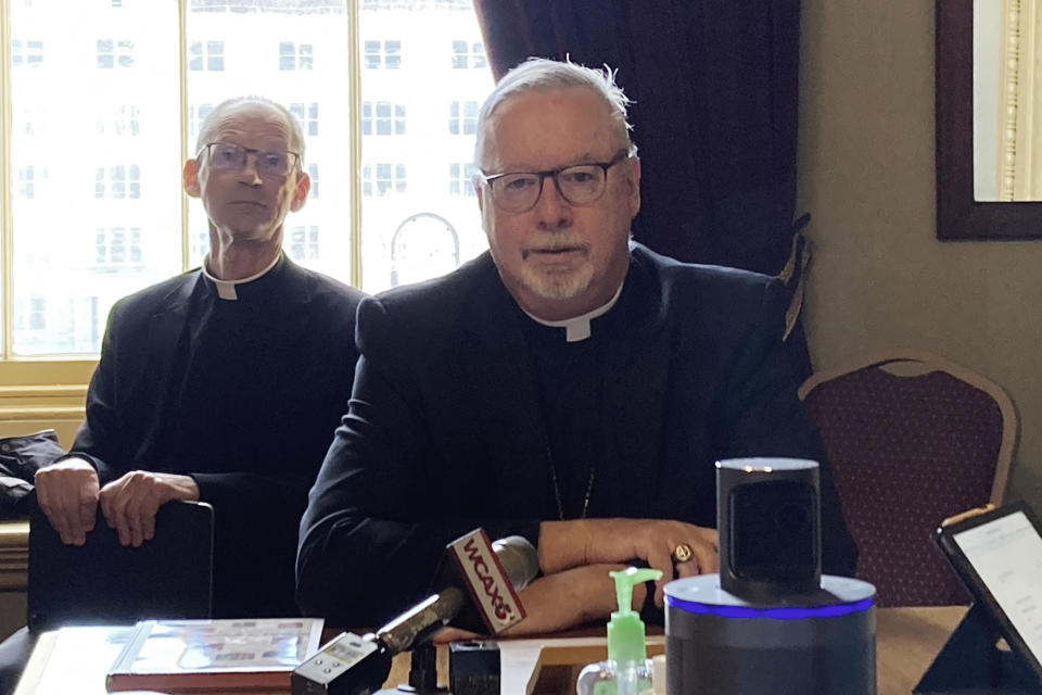 Bishop Christopher Coyne, of the Roman Catholic Diocese of Vermont, testifies before the Vermont Senate Judiciary Committee at the State House, Friday, March 3, 2023, in Montpelier, Vt. Coyne said the diocese is opposed to a bill that would remove an exemption to the state's child abuse and neglect reporting laws for members of the clergy. At rear left is Rev. Msgr. John McDermott. (AP Photo/Lisa Rathke)