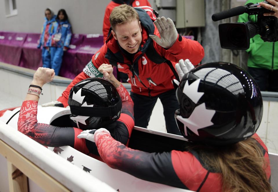 The team from Canada CAN-1, piloted Kaillie Humphries with brakeman Heather Moyse, cross into the finish area to win the gold medal in the women's bobsled competition at the 2014 Winter Olympics, Wednesday, Feb. 19, 2014, in Krasnaya Polyana, Russia. (AP Photo/Jae C. Hong)