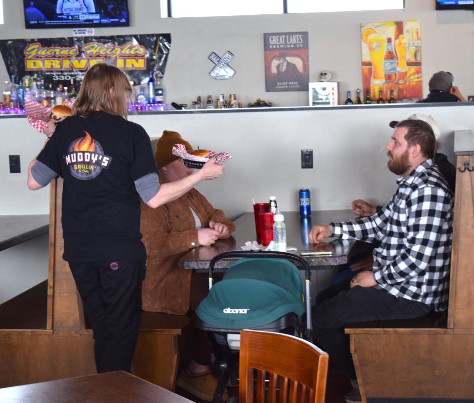 A waitress at Muddy's serves burgers to diners at the East Liberty Street, Wooster, restaurant. Wings are featured on Wednesdays, with a variety of choices in style and sauces.