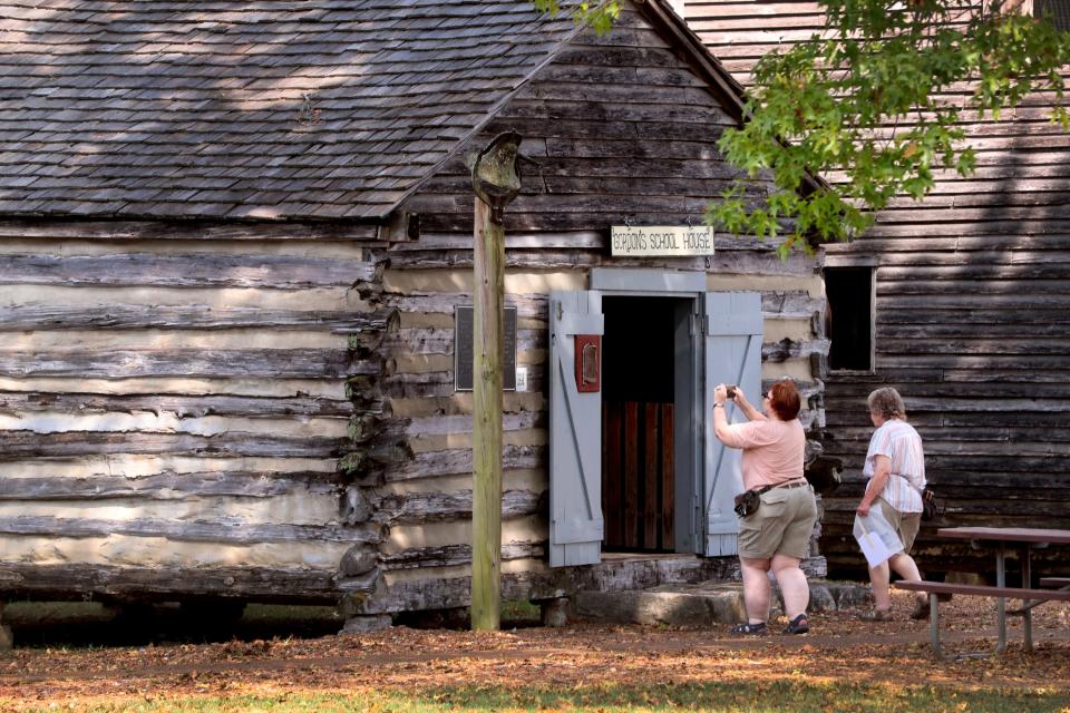 Lori Bravo and Loretta Smith of San Antonio, Texas stop by to see the World's Largest Cedar bucket that is on display at Cannonsburgh Village as they were passing through the area on Thursday, Sept. 7, 2023. Even though the women stopped to see the bucket they were please to see the other historical buildings and artifacts.