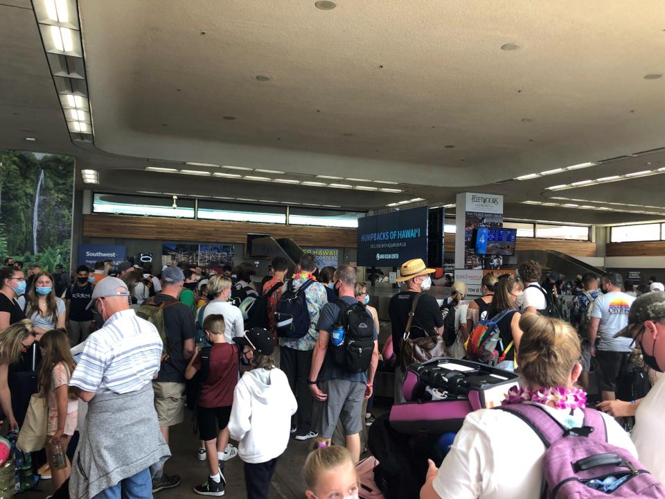 Passengers arriving in Maui wait for bags in the cramped baggage claim area of Kahului Airport. Hawaii has recently reduced its restaurant and bar capacity to stem the spread of COVID-19.