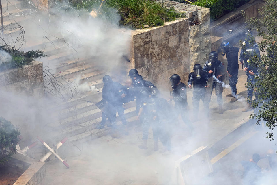 Riot policemen arrest a retired army soldier during a protest demanding better pay, in Beirut, Lebanon, Wednesday, March 22, 2023. Lebanese security forces fired tear gas to disperse hundreds of protesters who tried to break through the fence leading to the government headquarters in downtown Beirut Wednesday amid widespread anger over the harsh economic conditions in the country. (AP Photo/Bilal Hussein)