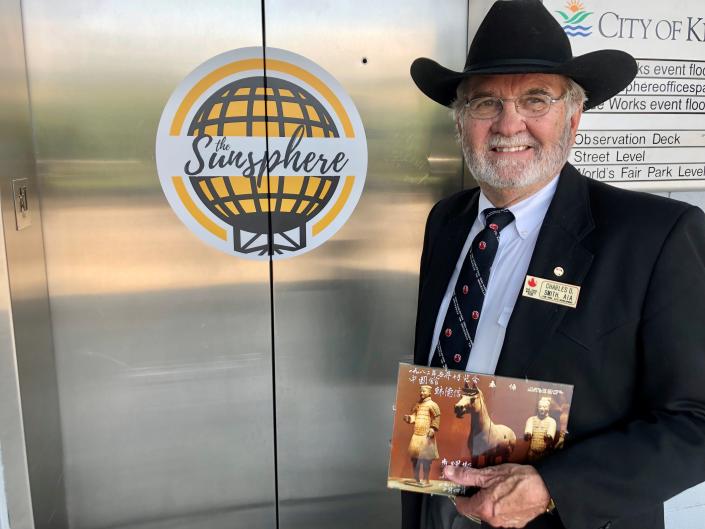 Architect Charlie Smith, who was vice president of site development during the 1982 World’s Fair, stands by the elevator doors at the base of the Sunsphere on May 10, 2022. He is wearing his 1982 World’s Fair tie and nametag and a cowboy hat symbolic of his work with rodeos.
