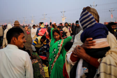 A devotee gets ready after taking a holy dip at Sangam, the confluence of the Ganges, Yamuna and Saraswati rivers, during "Kumbh Mela", or the Pitcher Festival, in Prayagraj, previously known as Allahabad, India, January 14, 2019. REUTERS/Danish Siddiqui