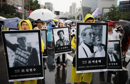 People march holding portraits of deceased victims of wartime forced labor during the Japanese colonial period, during an anti-Japan protest on Liberation Day in Seoul