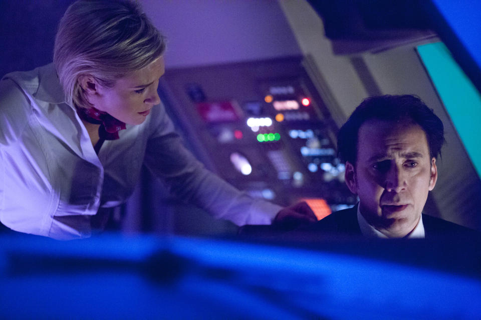 Nicky Whelan and Nicolas Cage in a cockpit.