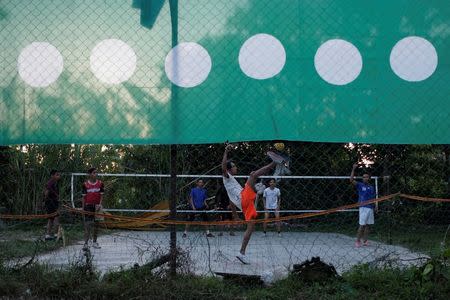 Youths play sepak takraw next to Parti Islam Se-Malaysia (PAS) banners at Kota Bharu in Kelantan, Malaysia April 12, 2018. Picture taken April 12, 2018. REUTERS/Stringer