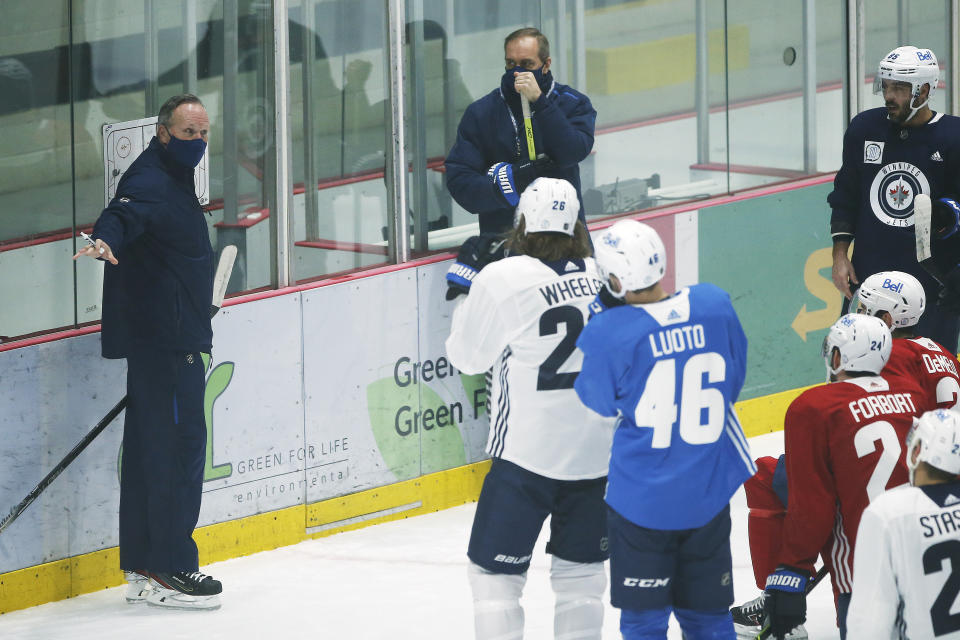 FILE - Winnipeg Jets assistant coach Dave Lowry, left, and head coach Paul Maurice talk to players during the first day of their NHL training camp in Winnipeg, Manitoba, Monday, Jan. 4, 2021. Jets coach Paul Maurice has resigned in a surprise move in his ninth year with the team. The team announced Maurice's decision on Friday, Dec. 17, 2021, and said it was effective immediately. Dave Lowry was elevated to interim coach. (John Woods/The Canadian Press via AP, File)