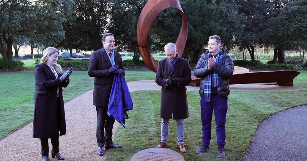 Leo Varadkar, Roderic O'Gorman and Rory O'Neill unveiling Ireland's first HIV monument. Four people stand clapping with the monument in the background.