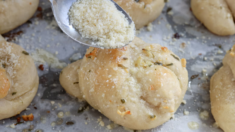 Parmesan sprinkling onto garlic knot