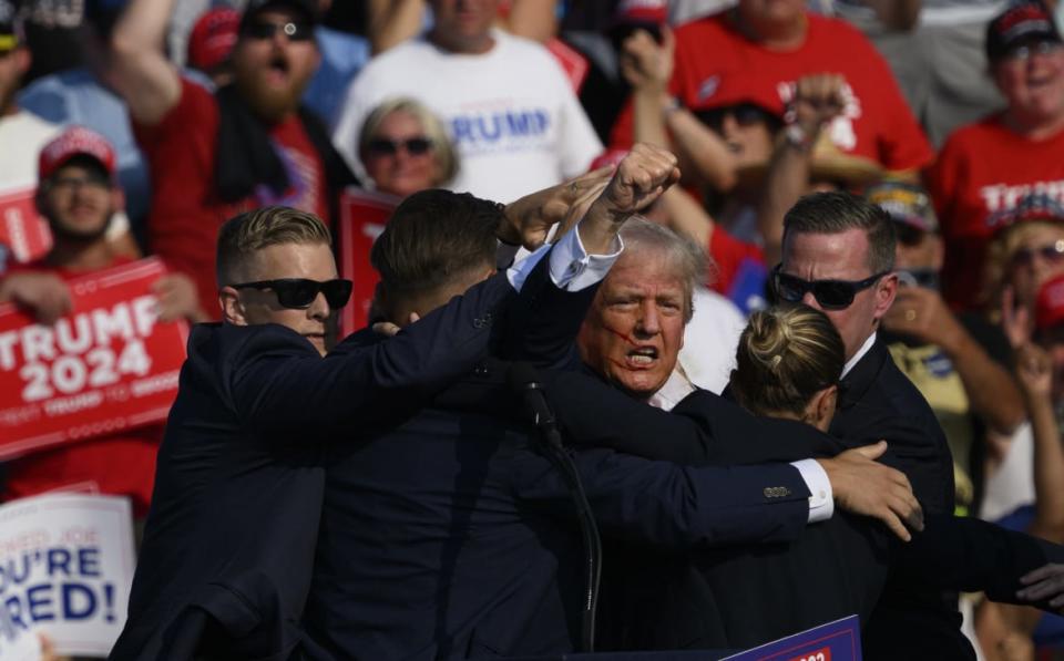 Republican presidential candidate, former U.S. President Donald Trump is whisked away by Secret Service after shots rang out at a campaign rally at Butler Farm Show Inc. on July 13, 2024 in Butler, Pennsylvania.