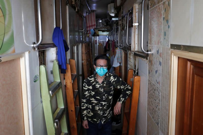 Simon Wong, 64, poses for a photo outside his 2 square metre subdivided residential unit, known as a "coffin home", following the outbreak of the new coronavirus, in Hong Kong