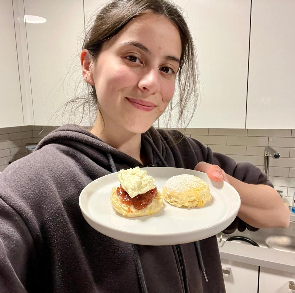 Adding jam and cream to the scone.