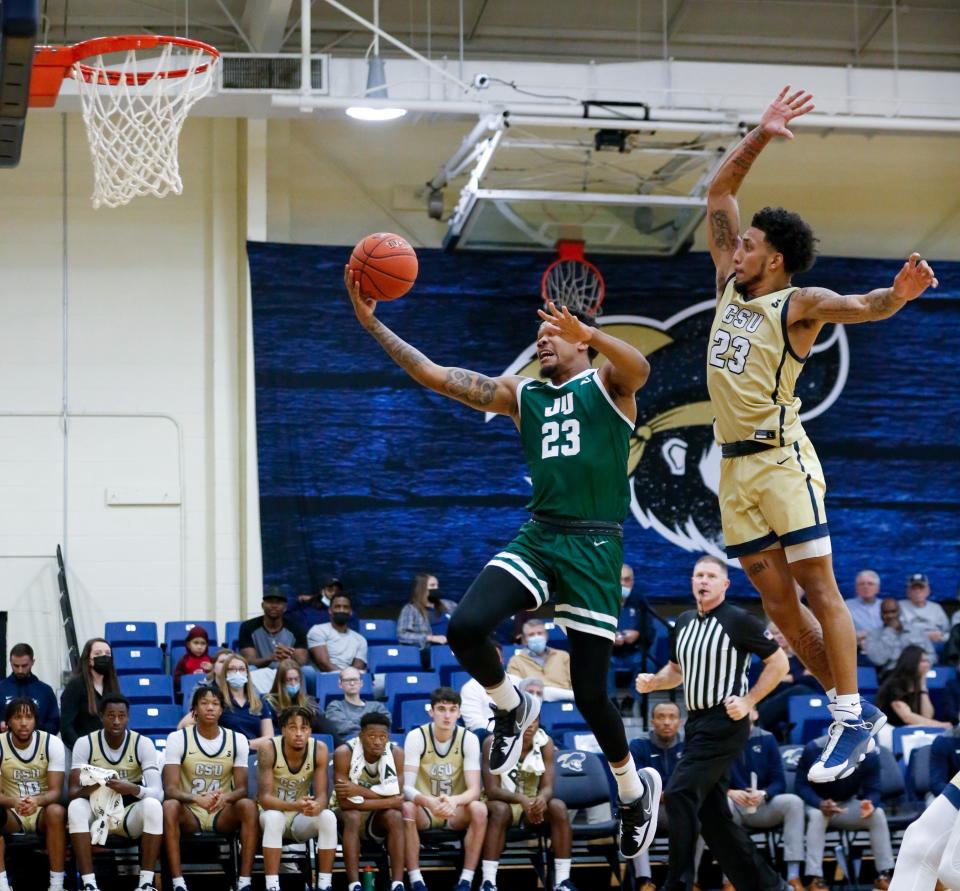 Jacksonville's Tyreese Davis drives to the basket ahead of Charleston Southern's Sean Price during last week's game, won by the Dolphins.