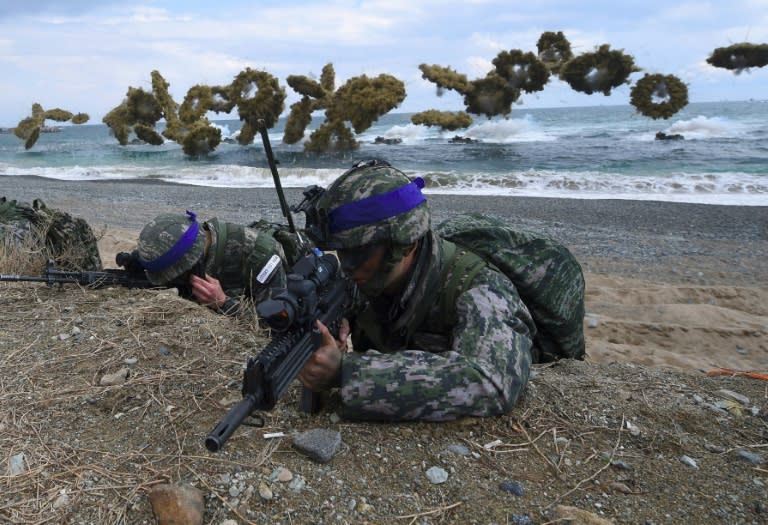 South Korean Marines take position on a beach as amphibious assault vehicles fire smoke shells during a joint landing operation by US and South Korean Marines in the southeastern port of Pohang on April 2, 2017