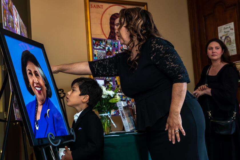 Sister Olga Molina Palacios with her 6-year-old son Moises Armando Palacios pays her respect at Gloria Molina's funeral.