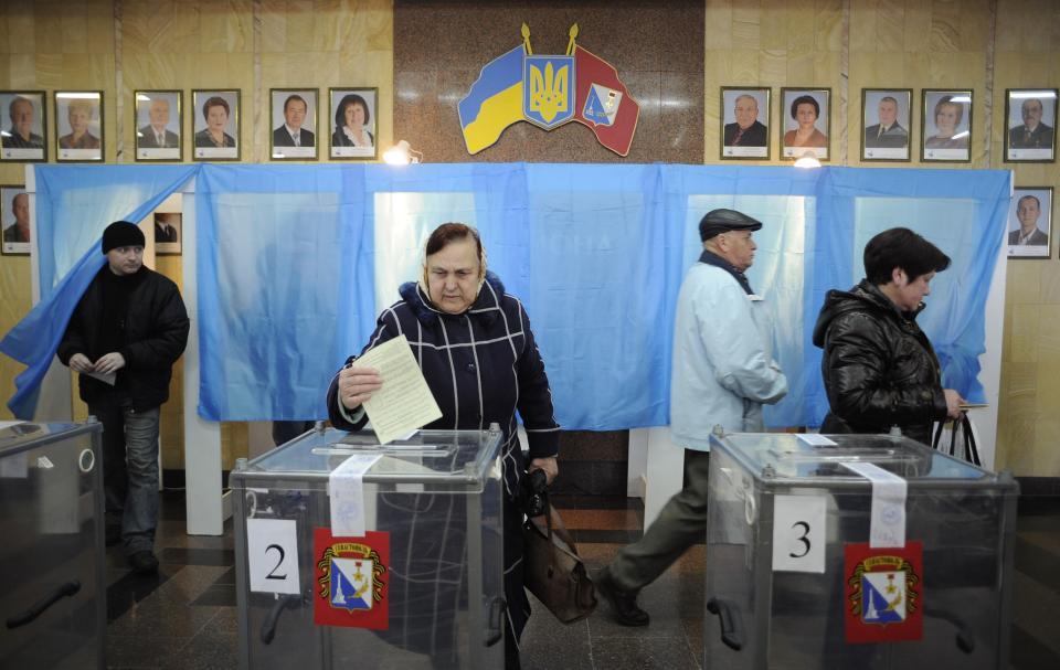 FILE - A woman votes at a polling station during the Crimean referendum to secede from Ukraine and join Russia, in Sevastopol, Crimea, on Sunday, March 16, 2014. Russia's annexation of Crimea has been seen by most of the world as an illegal land grab and recognized only by a few countries. (AP Photo, File)