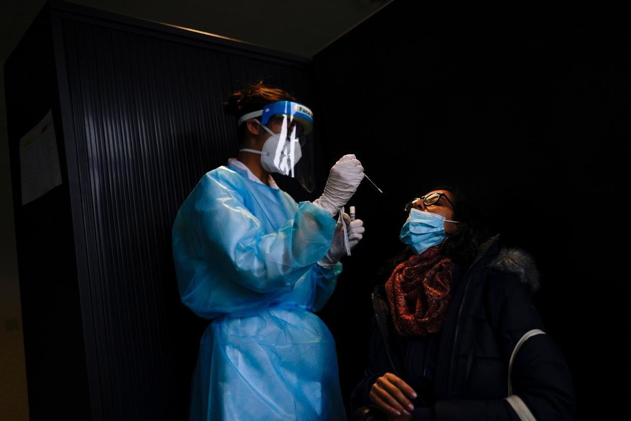 A medical worker, wearing full protective gear, takes a nose swab from a traveller, who arrived from UK, to be tested for Covid-19 at Gare du Midi international train station in Brussels (AP)