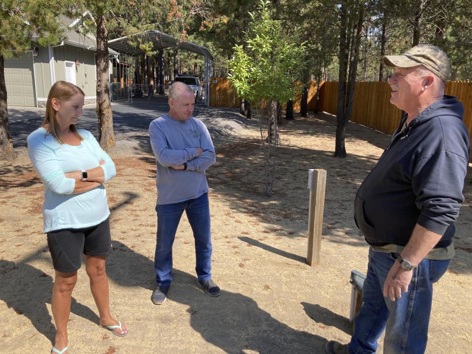 Left to right, Cindy and Jim Hooper and Rodger Jincks discuss water issues in their neighborhood in La Pine, Ore., on Aug. 26, 2021. Jincks' well ran dry and was having a new one drilled, and the Hoopers worry their well will also go dry as the water table lowers. Sheriff's deputies busted an illegal marijuana grow a block away recently and another, bigger grow had been nearby, using water from the same aquifer that the neighborhood uses. (AP Photo/Andrew Selsky)