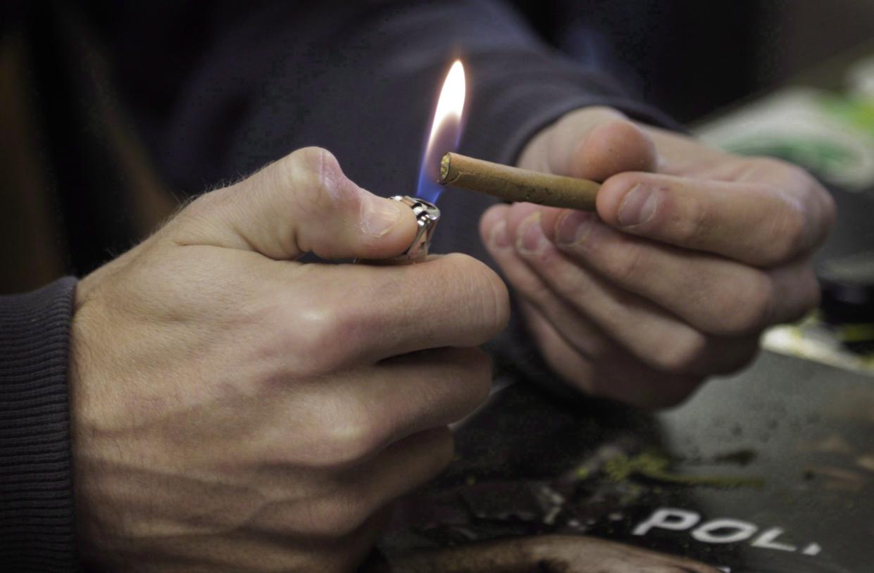 A marijuana user lights a joint at a vape lounge. Photo from CP Images
