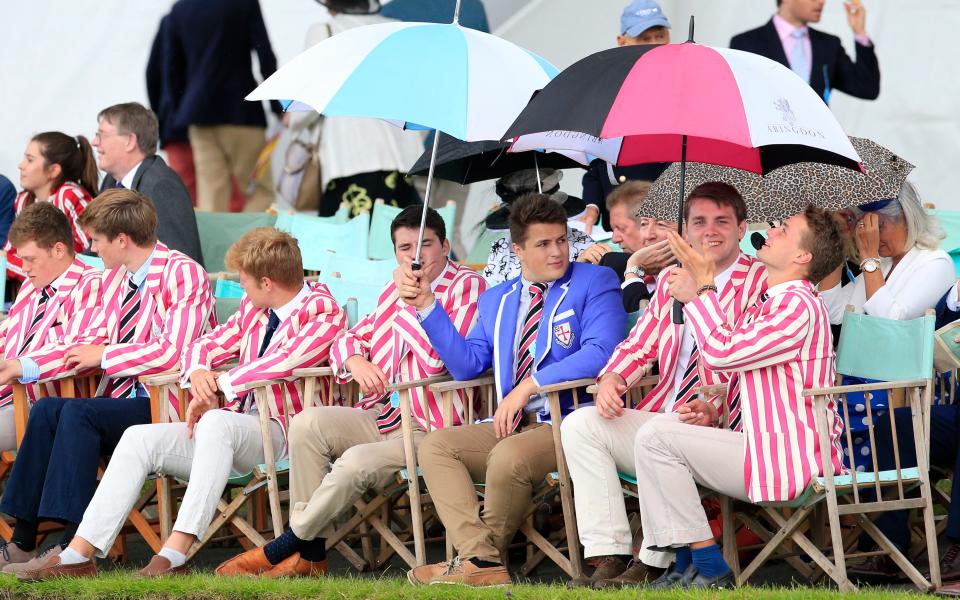 Spectators shelter under umbrellas - Credit: Jonathan Brady/PA Wire