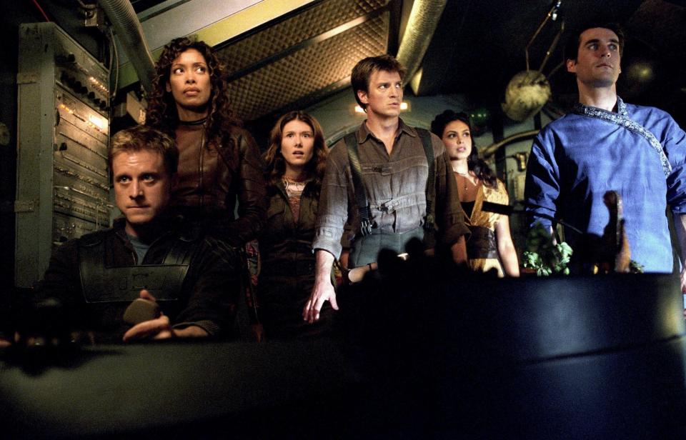 The crew of a spaceship assemble in the cockpit during a precarious situation in “Serenity”