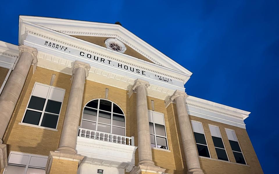 The Warrick County Courthouse as seen against a dark blue sky.