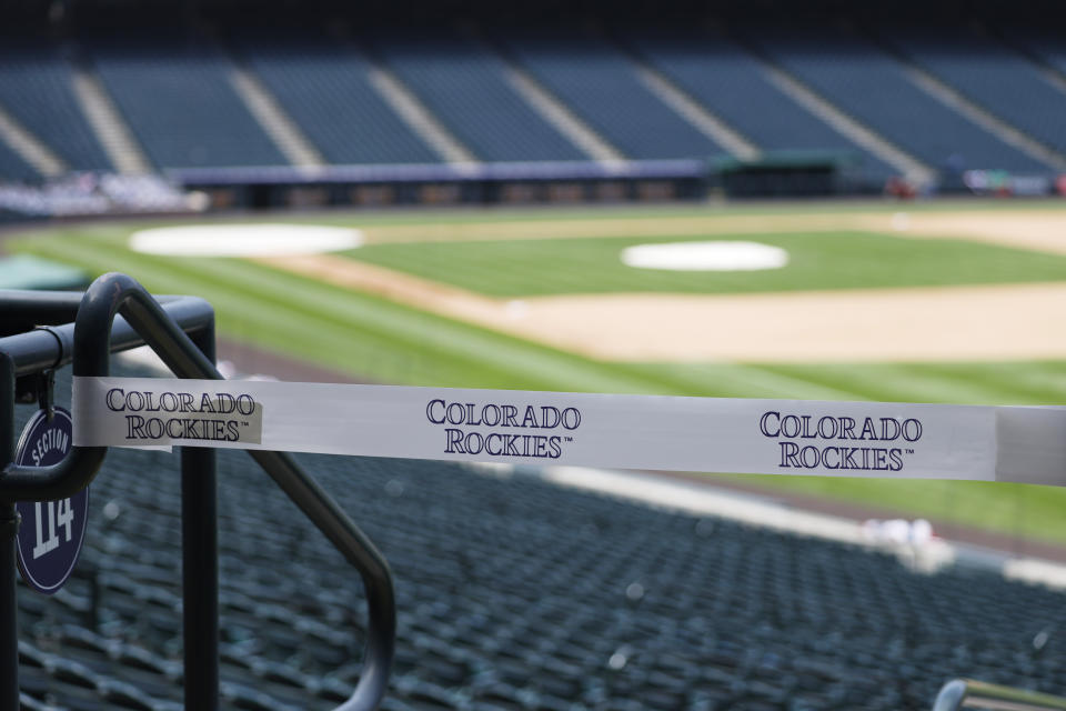 Caution tape closes off sections of seats along the first-base line in an empty Coors Field before the Colorado Rockies host the San Diego Padres in a baseball game Sunday, Aug. 2, 2020, in Denver. (AP Photo/David Zalubowski)