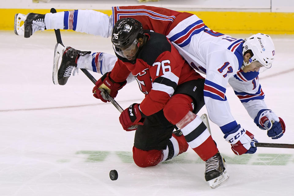 New York Rangers center Kevin Rooney (17) falls over New Jersey Devils defenseman P.K. Subban (76) during the first period of an NHL hockey game, Thursday, March 4, 2021, in Newark, N.J. (AP Photo/Kathy Willens)