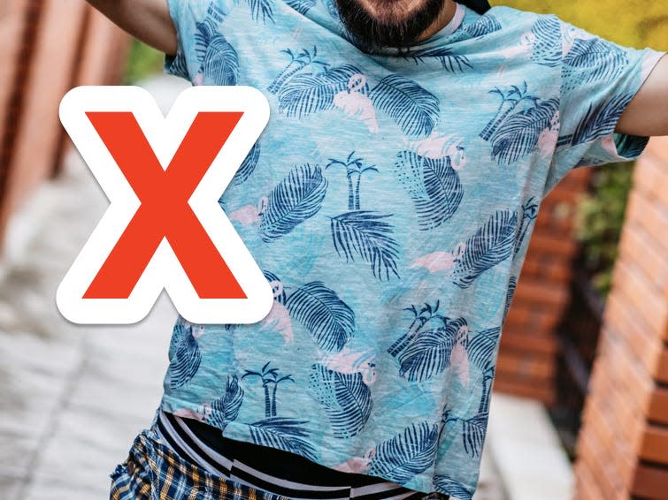 red x over street style man wearing blue flamingo patterned shirt and checked pants holding a skateboard