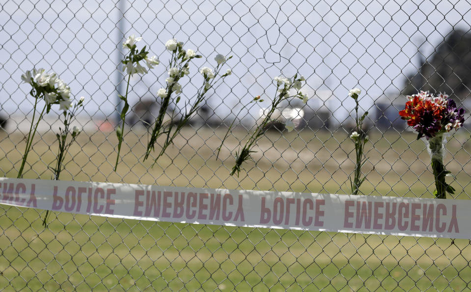 Flower sit on a fence on the waterfront in Whakatane, New Zealand, Tuesday, Dec. 10, 2019. A volcanic island in New Zealand erupted Monday Dec. 9 in a tower of ash and steam while dozens of tourists were exploring the moon-like surface, killing multiple people and leaving many more missing.(AP Photo/Mark Baker)