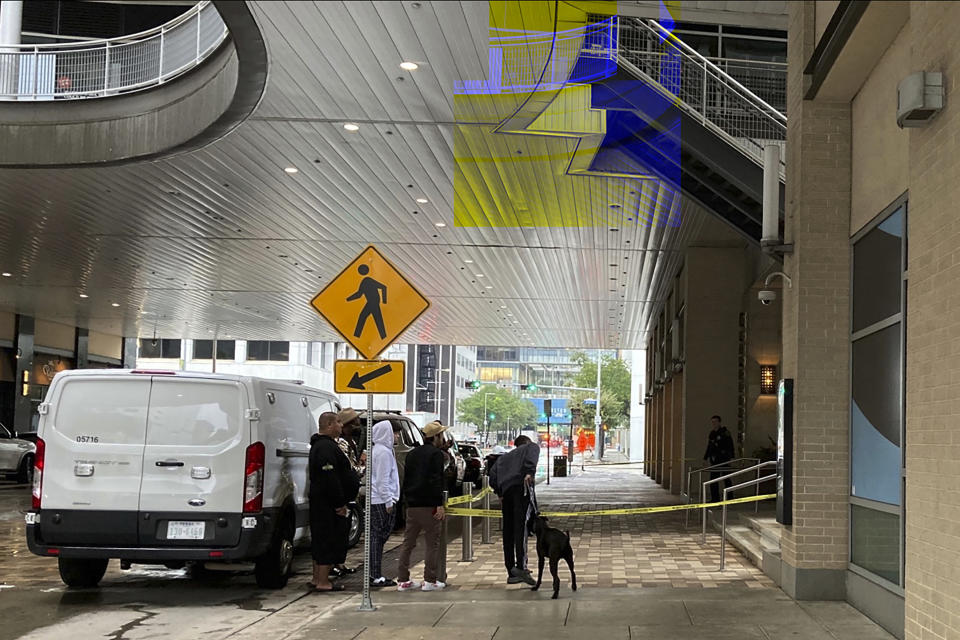 Fans of Migos rapper Takeoff looked on Tuesday, Nov. 1, 2022 as Houston police were at the scene of a shooting at a retail complex in downtown Houston. A representative of the group Migos has confirmed that Takeoff was killed during a shooting at a bowling alley at the three-story retail complex. (AP Photo/Juan Lozano)