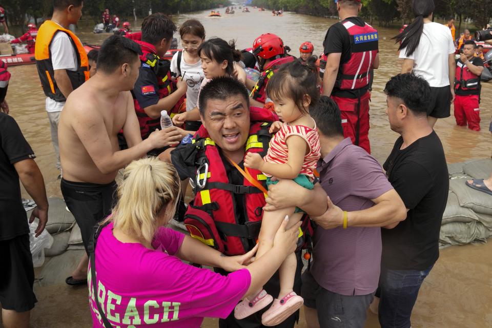 FILE - Rescuers using rubber boats evacuate trapped residents through floodwaters in Zhuozhou in northern China's Hebei province, south of Beijing, Aug. 2, 2023. The Philippines, India and China had the most children displaced by climate hazards, accounting for nearly half. (AP Photo/Andy Wong, File)