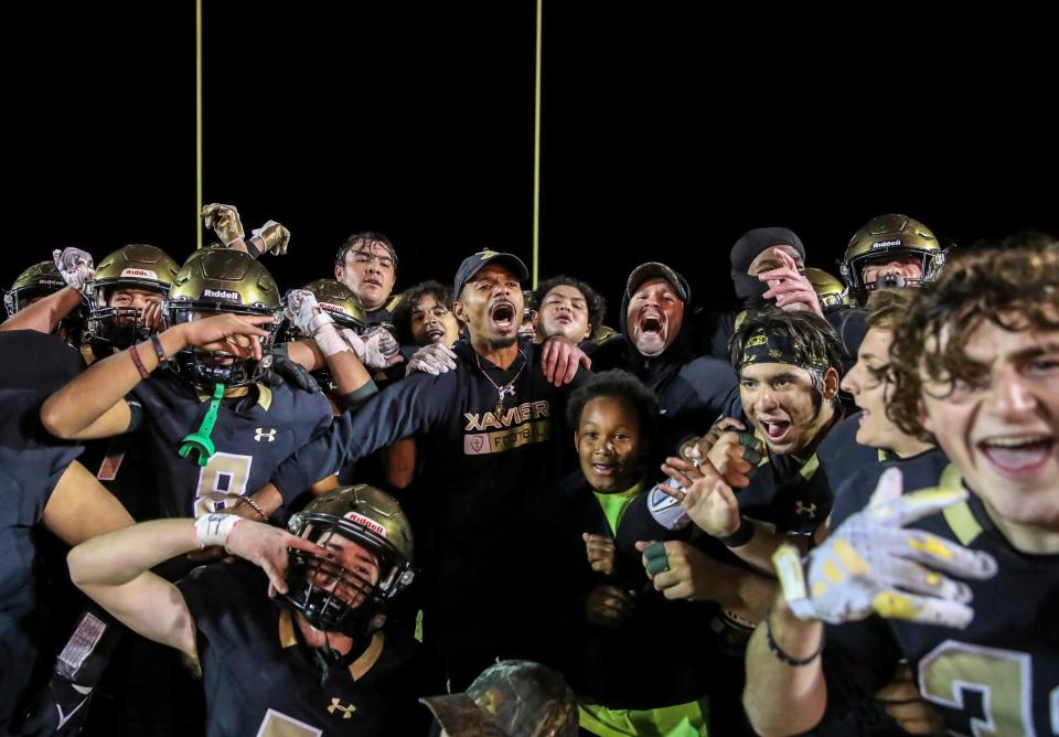 Xavier Prep head coach James Dockery celebrates a win with his players after winning their second-round playoff game at Xavier College Preparatory High School in Palm Desert, Calif., Friday, Nov. 10, 2023.