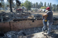 Shawn Thornton hugs his wife, Shannon Thornton, next to the rubble of their burned home Tuesday, Sept. 8, 2020, in Malden, Washington the day after a fast-moving wildfire swept through the tiny town west of Rosalia. Shawn and Shannon weren't home at the time, but their son Cody was and managed to get their dog and a few belongings before leaving just minutes before the flames swept through. (Jesse Tinsley/The Spokesman-Review via AP)