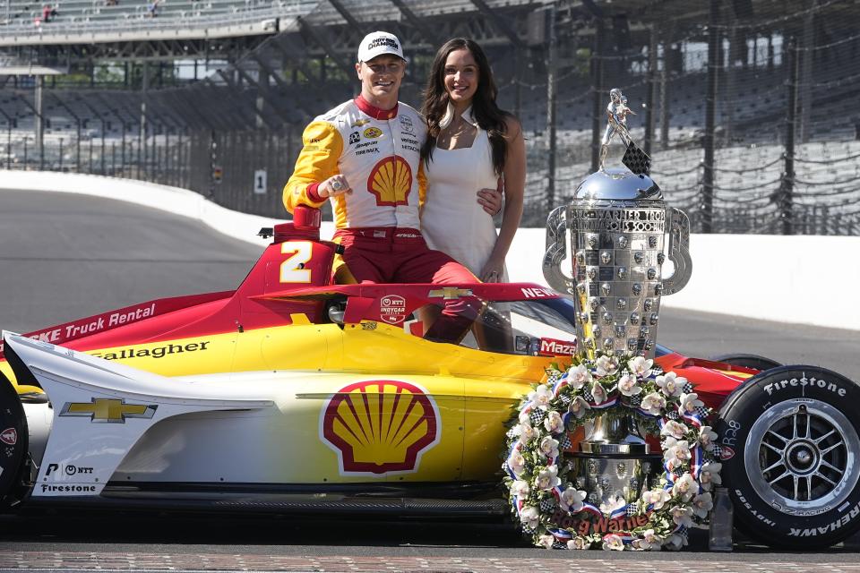 Josef Newgarden poses with his wife, Ashley, and the Borg-Warner Trophy during the traditional winners photo session at Indianapolis Motor Speedway, Monday, May 29, 2023, in Indianapolis. Newgarden won the 107th running of the Indianapolis 500 auto race Sunday. (AP Photo/Darron Cummings)