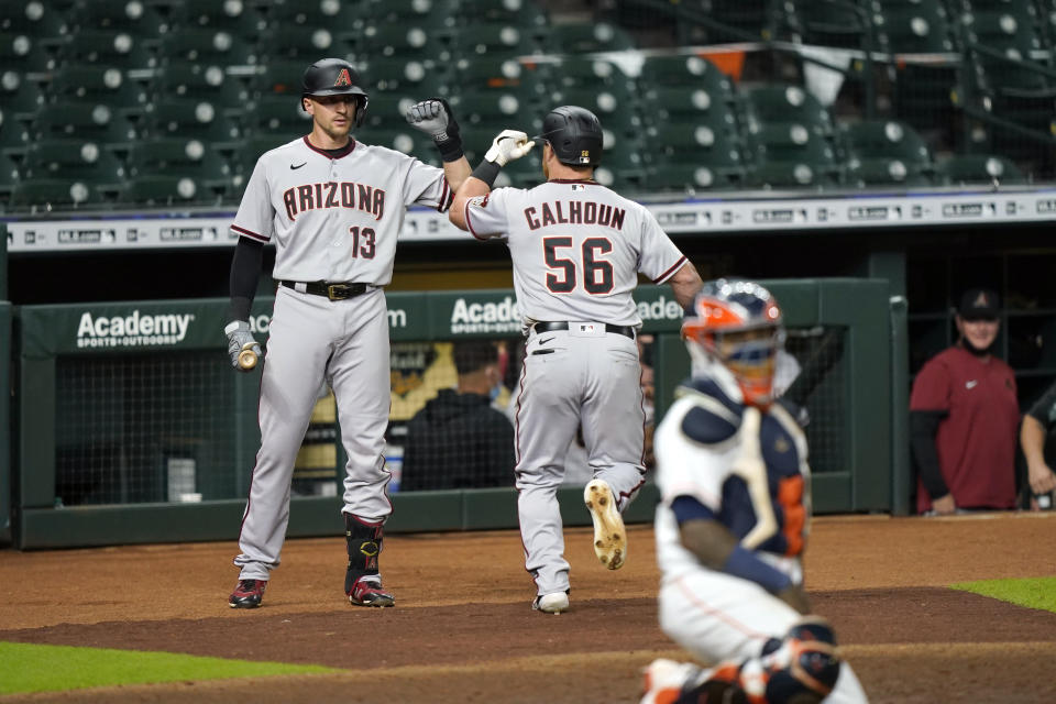 Arizona Diamondbacks' Kole Calhoun (56) celebrates with Nick Ahmed (13) after hitting a home run against the Houston Astros during the eighth inning of a baseball game Friday, Sept. 18, 2020, in Houston. (AP Photo/David J. Phillip)