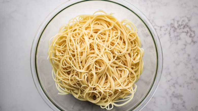 cooked spaghetti in glass bowl