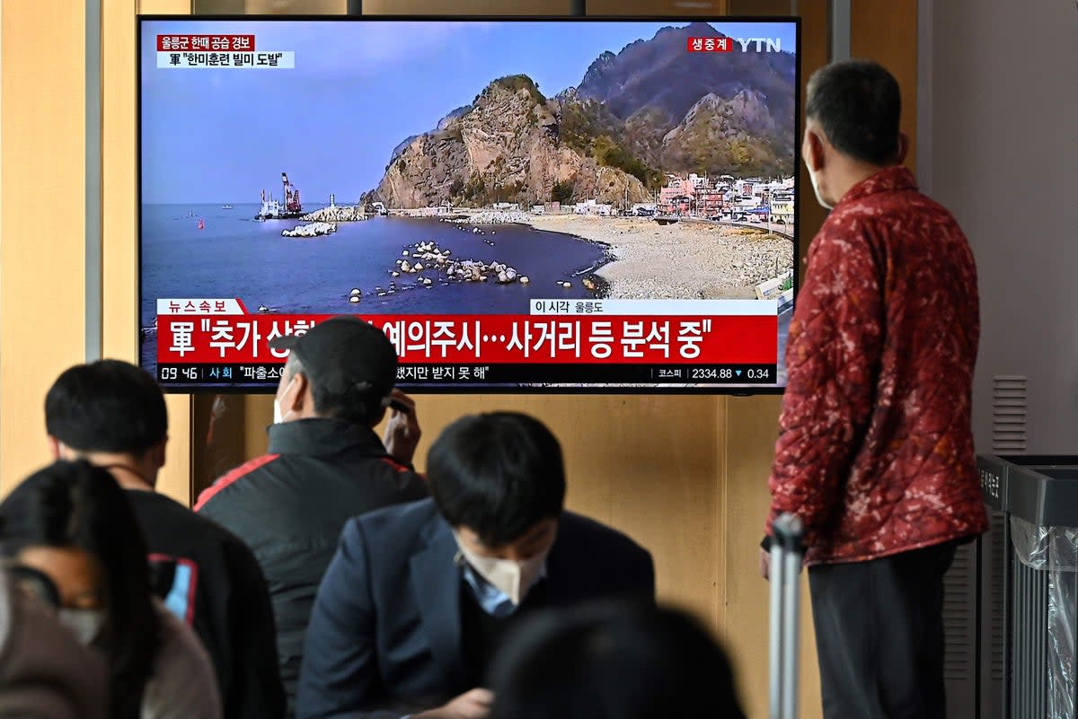 People watch a television screen showing a news broadcast with live footage of the island of Ulleungdo at a railway station in Seoul (AFP via Getty Images)