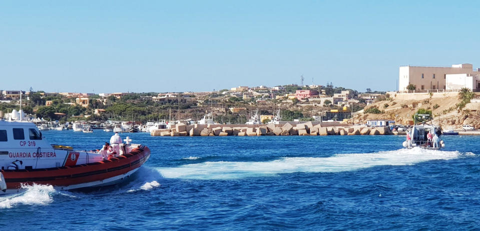 Migrants are evacuated by Italian Coast guards from the Open Arms Spanish humanitarian boat at the coasts of the Sicilian island of Lampedusa, southern Italy, Saturday, Aug. 17, 2019. Italy’s hard-line interior minister buckled under pressure Saturday and agreed to let 27 unaccompanied minors leave a migrant rescue ship after two weeks at sea, temporarily easing a political standoff that has threatened the viability of the populist government. (Elio Desiderio/ANSA Via AP)