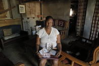 Mandy Sinanyoni, nanny of the three daughters of Graham and Lauren Dickason, holds photographs of the Dickason family in her Pretoria, South Africa home, Friday Sept. 17, 2021. Maya, Karla and Liane Dickason were found dead in the Timaru, New Zealand home they just move into from South Africa. A 40-year-old woman identified by police as Lauren Dickason was charged Friday with killing three young girls in a crime that has shocked New Zealand. (AP Photo/Sebabatso Mosamo)