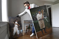 Baseball artist Graig Kreindler rearranges three of his paintings in progress, Wednesday, April 29, 2020, at his residence in the Brooklyn borough of New York. At left is a portrait of Hall of Famer and Negro Leagues catcher Josh Gibson showing off his swing, based on a photograph from 1939-40 season with the Cangrejeros (Crabbers) de Santurce, part of the Puerto Rican semi-professional baseball league. The painting at right depicts Babe Ruth during the 1920 season, Ruth's first with the Yankees, at the Polo Grounds, where the team played during most of the 1910's and 1920's before the Yankee Stadium was built in 1923. The middle painting shows some kids listening to Babe Ruth, who are obscured by Kreindler's right leg. (AP Photo/Kathy Willens)