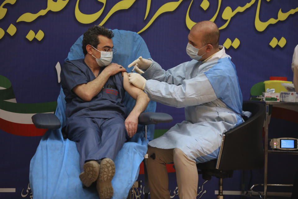Dr. Fattah Ghazi from the Imam Khomeini hospital receives a Russian Sputnik V coronavirus vaccine in a staged event at Imam Khomeini Hospital in Tehran, Iran, Tuesday, Feb. 9, 2021. Iran on Tuesday launched a coronavirus inoculation campaign among healthcare professionals with recently delivered Russian Sputnik V vaccines as the country struggles to stem the worst outbreak of the pandemic in the Middle East with its death toll nearing 59,000. (AP Photo/Vahid Salemi)