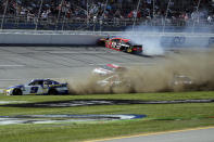 NASCAR Cup Series driver Chase Elliott (9), NASCAR Cup Series driver William Byron (24), and NASCAR Cup Series driver Alex Bowman (48) slide through the infield as NASCAR Cup Series driver Martin Truex Jr. (19) hits the outside wall during the Geico 500 NASCAR Sprint Cup auto race at Talladega Superspeedway Sunday, April 25, 2021 in Talladega, Ala. (AP Photo/Butch Dill)