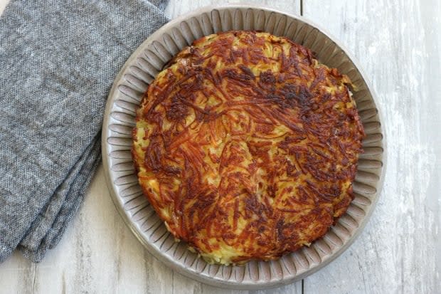 Rosti is baked slowly in the skillet until well crisped on the bottom, then carefully turned over so that both sides are crisp and the cheese has melted.