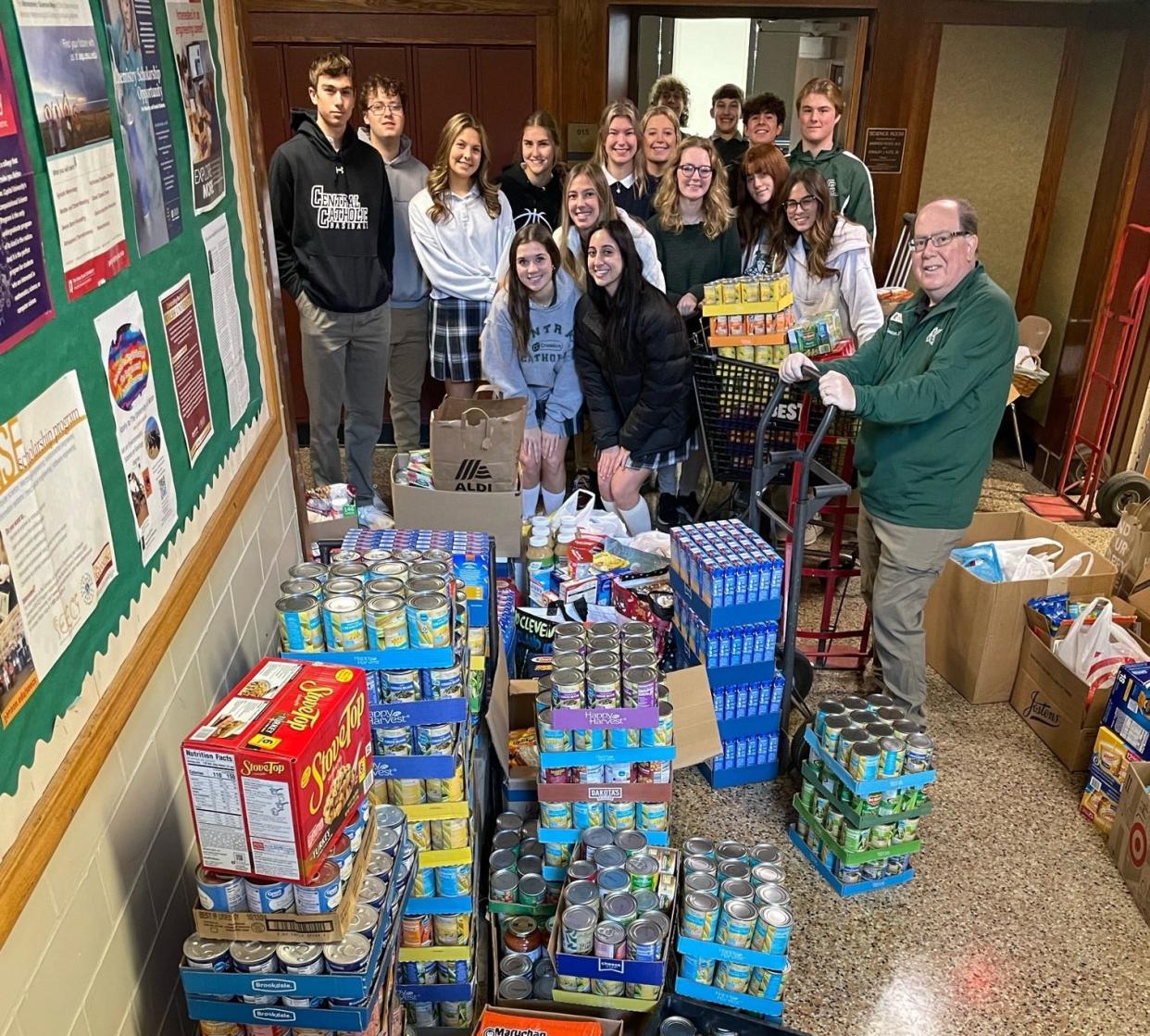 Central Catholic high School student and Deacon Randy Smith (right) with he more than 6,000 goods they recently collected for their school's annual food drive.