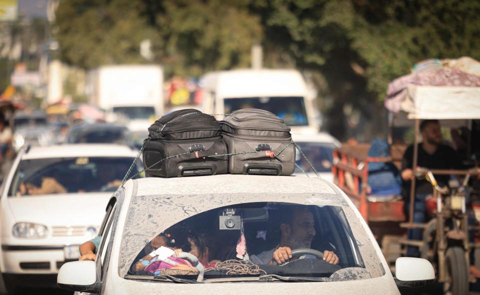 Palestinians with their belongings flee northern Gaza City following the Israeli army's warning to leave their homes before an expected ground offensive in Gaza City on Oct. 13, 2023. Palestinians carried belongings through the rubble-strewn streets of Gaza City on Oct. 13, searching for refuge as Israel's army warned residents to flee immediately before an expected ground offensive in retaliation against Hamas for the deadliest attack in Israeli history.