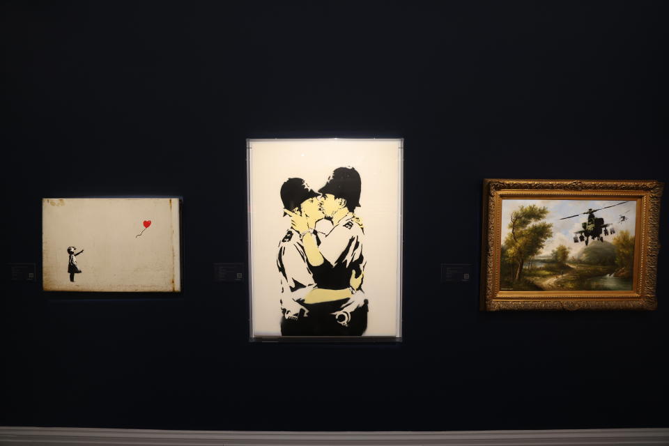 Banksy's Girl with Balloon, Kissing Coppers and Choppers from the collection of Robbie Williams on display at Sotheby's auction house in London