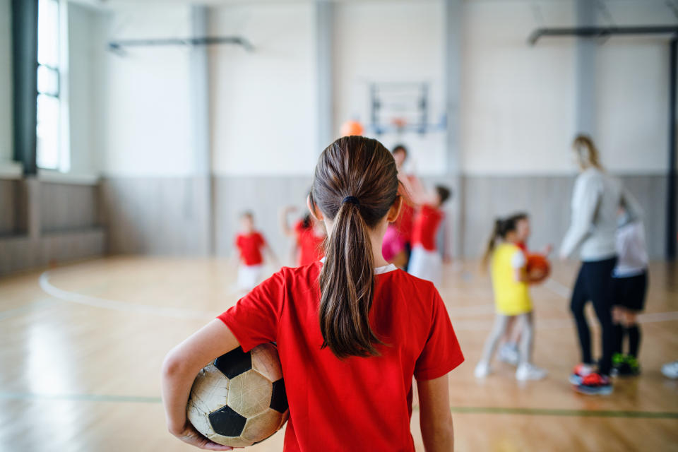 Una niña sujeta un balón de fútbol. (Foto: Getty Images).