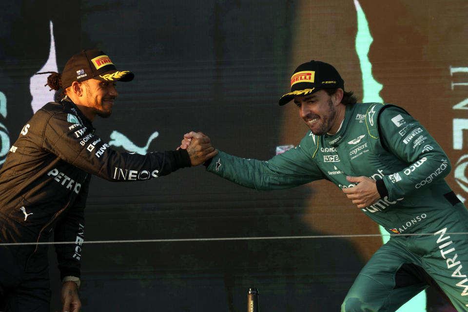 Mercedes driver Lewis Hamilton of Britain, left, and Aston Martin driver Fernando Alonso of Spain shake hands on the podium after the Australian Formula One Grand Prix at Albert Park in Melbourne, Sunday, April 2, 2023. Hamilton came 2nd and Alonso took 3rd. (AP Photo/Asanka Brendon Ratnayake)